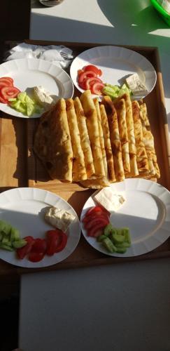 three plates of food on a table with vegetables at PROKLETIJE eko katun Vusanje in Gusinje