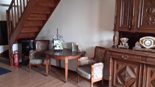 a dining room with a table and chairs and a staircase at Au Gallodrome Maison d'hôtes et Table d'hôtes en Estaminet privé in Drincham