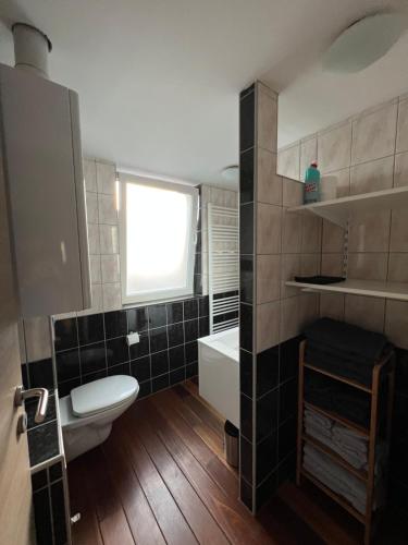 een badkamer met een toilet, een wastafel en een raam bij Le Pic Dînantais - Appartement cosy ✮ in Dinant