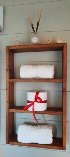 una mensola con asciugamani bianchi e nastro rosso di LAS ESCAMADAS ecocottage a Punta Del Diablo