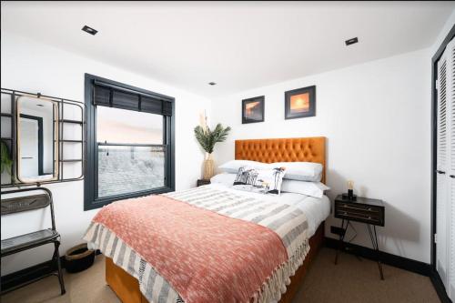 een slaapkamer met een bed en een raam bij CAPTAINS LOFT in Falmouth