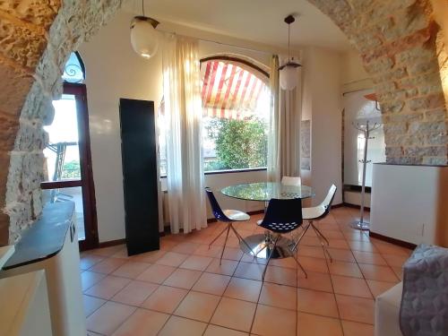 Assisi Garden Suite في أسيسي: غرفة معيشة مع طاولة وكراسي ونافذة