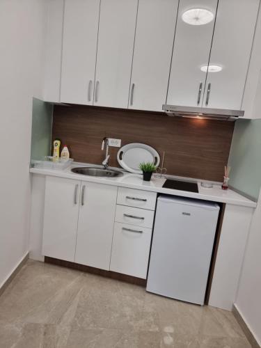 a kitchen with white cabinets and a sink at Ebra Lux Apartmani in Dobra Voda