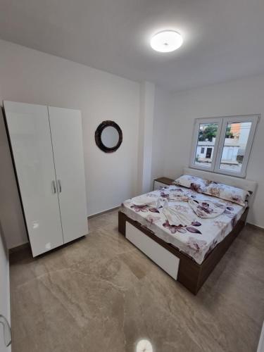 a bedroom with a bed and a cabinet in it at Ebra Lux Apartmani in Dobra Voda