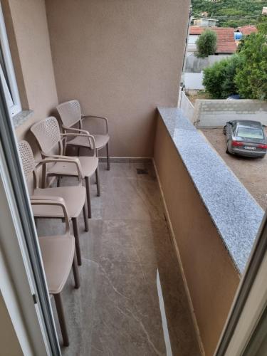 a room with chairs and a balcony with a car at Ebra Lux Apartmani in Dobra Voda