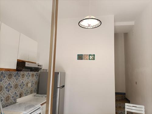 a kitchen with a refrigerator and a clock on the wall at La casetta a Scopello in Scopello