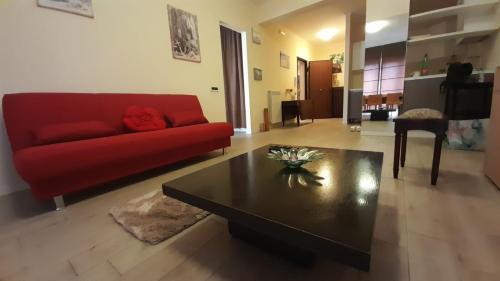 a living room with a red couch and a coffee table at la passeggiata in Lido di Ostia