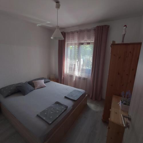 a bedroom with a large bed and a window at Villa Pagar - with jacuzzi - Renovated in 2022 in Povljana