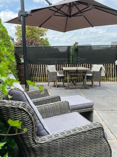 a patio with a table and chairs and an umbrella at B&B Mir Lo in Mierlo Adults only in Mierlo