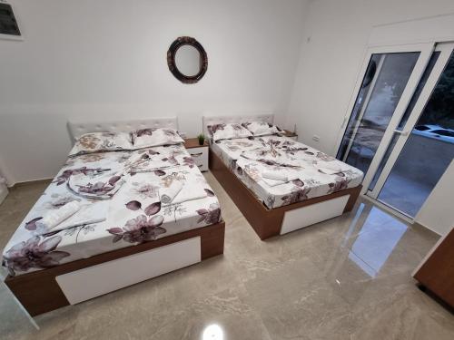 two twin beds in a room with a window at Ebra Lux Apartmani in Dobra Voda