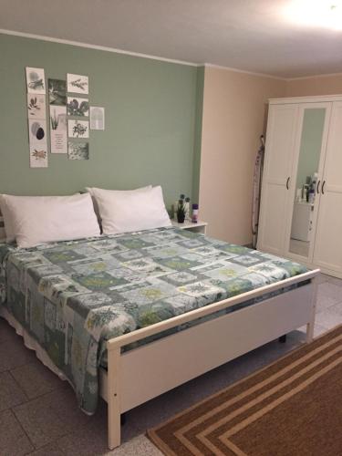 een slaapkamer met een groot bed met een groene muur bij Etna home in Santa Venerina