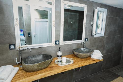 a bathroom with two sinks and two mirrors at Villa Angelos in Ermioni