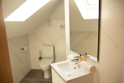 a white bathroom with a sink and a toilet at Apartamentos Avenida Premium in Vila Real