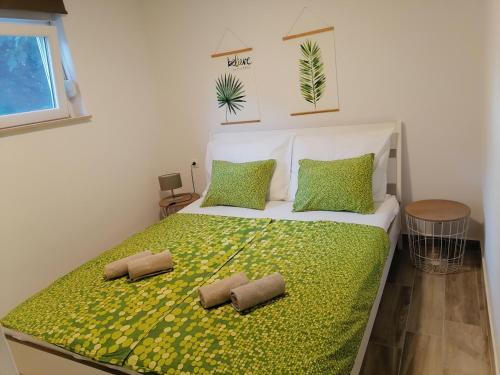 een slaapkamer met een groot bed met groene lakens en kussens bij Small guest House Punta Pakoštane in Pakoštane