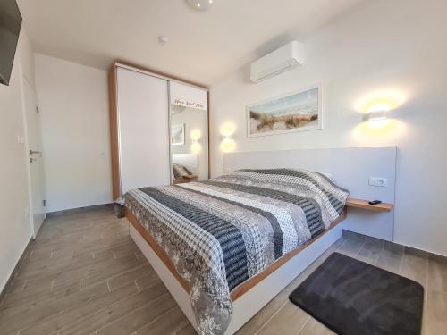 Dormitorio pequeño con cama y espejo en Belle oasis, en Novi Vinodolski