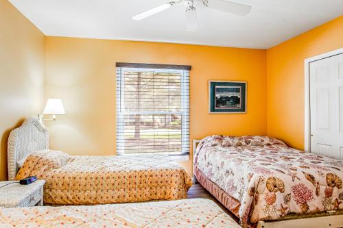 - 2 lits dans une chambre aux murs orange dans l'établissement Sea Colony --- 16004 Bayberry Court, à Bethany Beach