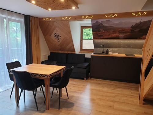 ein Wohnzimmer mit Tisch und Couch in der Unterkunft Willa Strążyski Potok in Zakopane