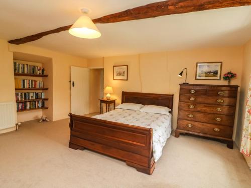 a bedroom with a wooden bed and a dresser at Cowstonegill in Bradley