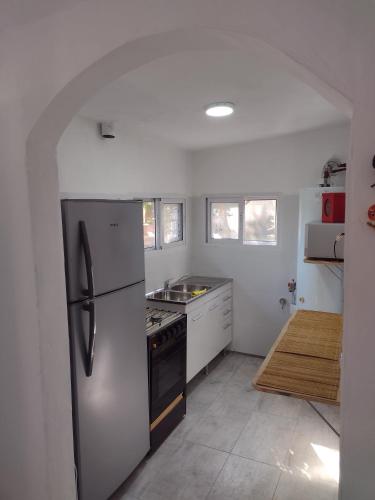 a kitchen with a stainless steel refrigerator and a stove at Cabañas Esferas de Cristal in Capilla del Monte