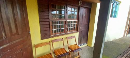 two chairs in front of a building with a door at Magic Island Casas in Florianópolis