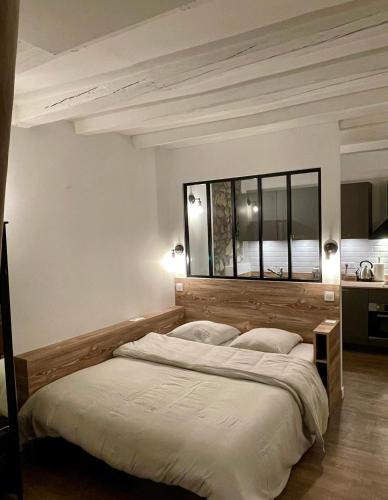 une chambre avec un grand lit et une grande fenêtre dans l'établissement La loge de pierre au coeur de la vieille ville d Annecy, à Annecy