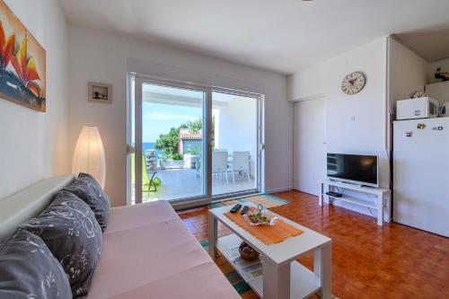 a living room with a couch and a table at Holiday Home Andrea in Primošten