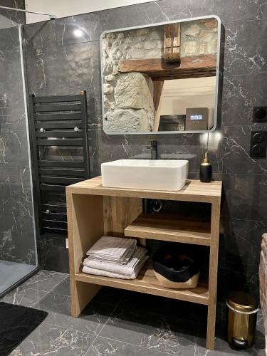 une salle de bain avec un lavabo et un miroir dans l'établissement La loge de pierre au coeur de la vieille ville d Annecy, à Annecy