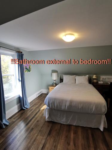 a bedroom with a large bed and a window at By The River B&B in Fredericton