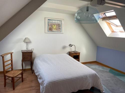a bedroom with a bed and a chair in a attic at Les Oiseaux de Passage in Gignac