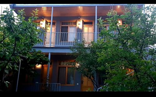a building with a balcony with trees in front of it at Andranik B&B in Goris