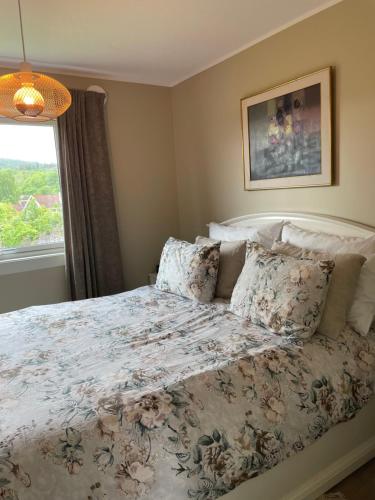 um quarto com uma cama com colcha floral e uma janela em Modern and Cozy home with an outstanding view em Asker