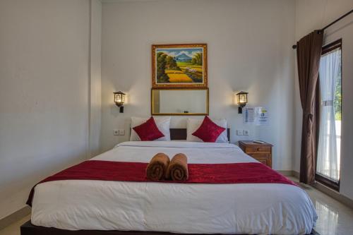 een slaapkamer met een bed met twee paar schoenen erop bij L Degus Hostel in Nusa Penida