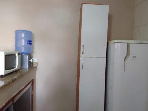 a kitchen with a white refrigerator and a microwave at Menina da Lua in Rio das Ostras