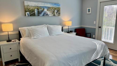 Dragonfly Guest House في أوجونكويت: غرفة نوم بسرير ابيض كبير ومصباحين