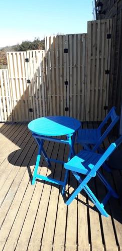 a blue picnic table and two chairs on a deck at Carilafquen Habitaciones en Suite in Valparaíso
