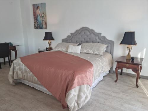 a bedroom with a bed with two tables and two lamps at Hotel Boutique Grand Cru in Santa Cruz