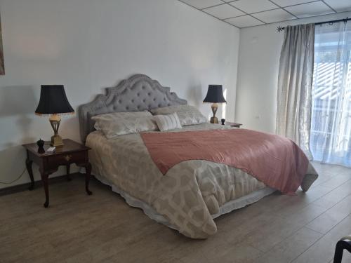 a bedroom with a large bed with two lamps on tables at Hotel Boutique Grand Cru in Santa Cruz