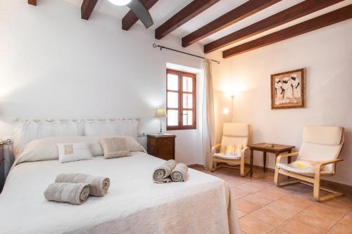 Un dormitorio con una cama blanca con toallas. en Fabulous Rural House with views to the mountains with swimming pool, en Caimari
