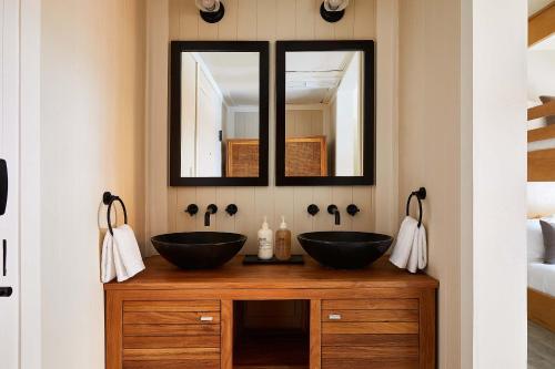 a bathroom with two sinks and a mirror at Life House, South of Fifth in Miami Beach