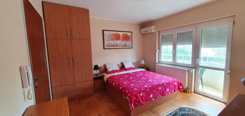 um quarto com uma cama com um cobertor rosa em Julija 2 em Pančevo