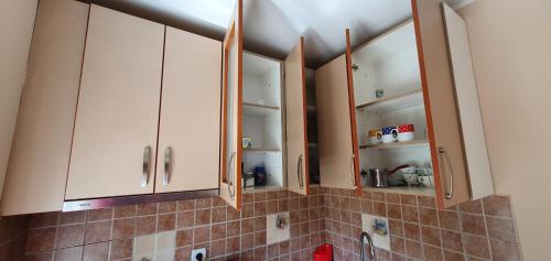 a kitchen with white cabinets and a sink at Julija 2 in Pančevo
