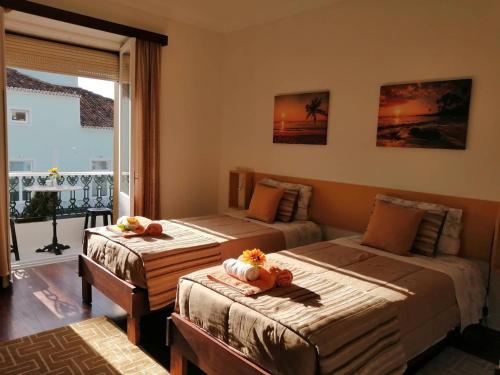 a bedroom with two beds and a window at City's Heart Guesthouse in Ponta Delgada