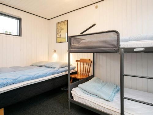a room with two bunk beds and a chair at Holiday home Bogense XXXIII in Bogense