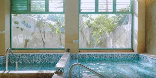 a bathroom with a swimming pool with a window and a tub at Kenting Long Beach Hotel in Checheng
