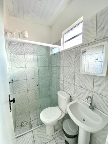 a bathroom with a white toilet and a sink at Pousada Rio Alegre in Santo Amaro