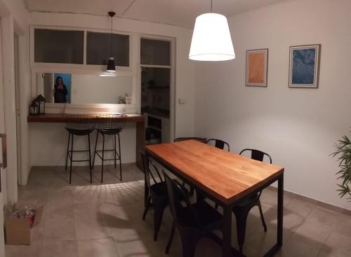 cocina y comedor con mesa de madera y sillas en PUNTO COLON en Mendoza