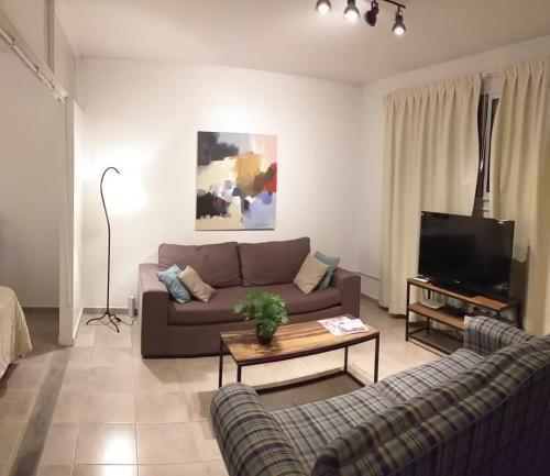 a living room with a couch and a tv at PUNTO COLON in Mendoza