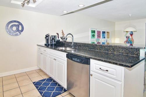 uma cozinha com um lavatório e uma máquina de lavar louça em Holiday Villas II 413 em Clearwater Beach