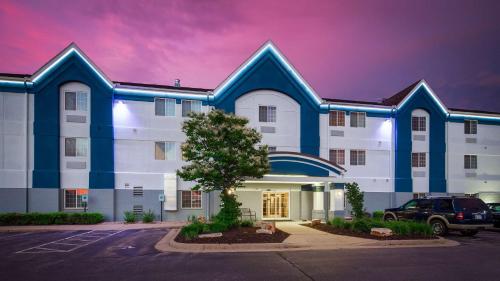a building with a car parked in a parking lot at Best Western Plus Wausau-Rothschild Hotel in Rothschild