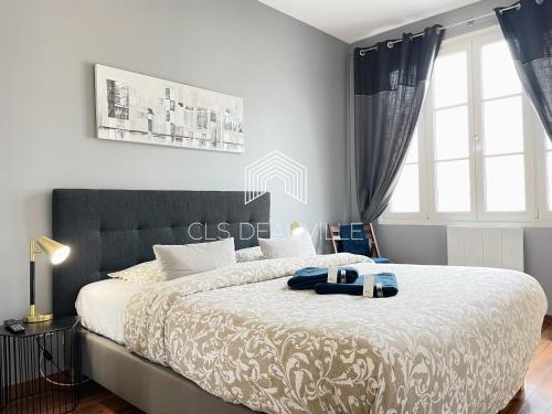Appartement Coeur de Deauville في دوفيل: غرفة نوم بسرير كبير عليها روب ازرق
